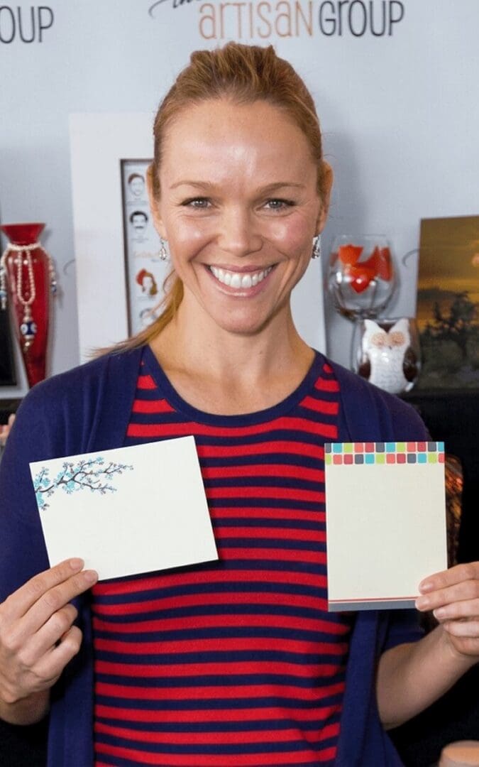 Smiling woman displaying colorful notepads